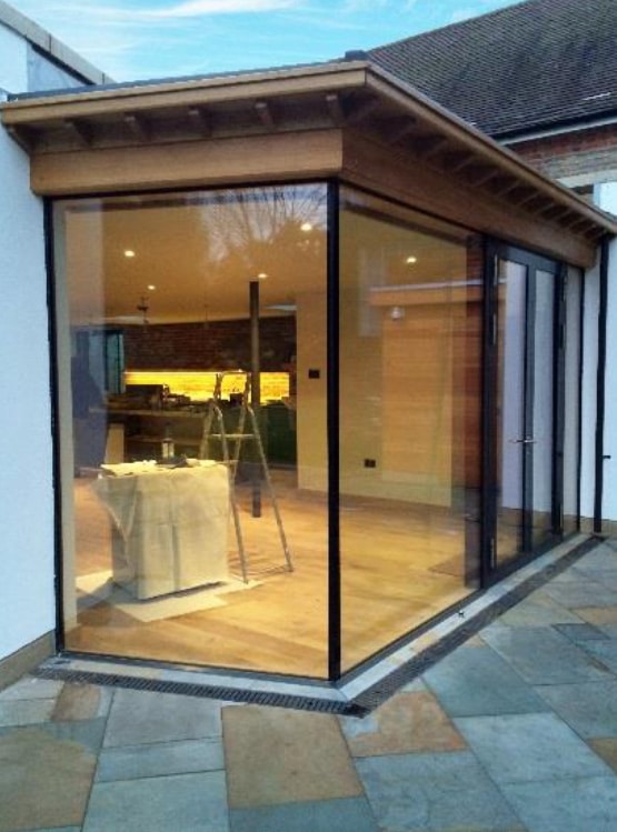 A large glass door featuring bespoke shuffle glazed screens for a frameless appearance