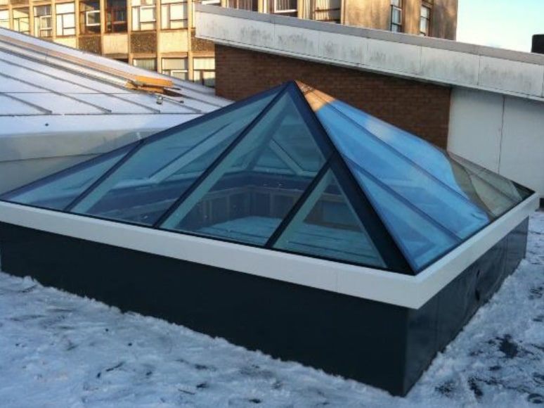 Installed modern glass rooflight with black primed framework on school refractory extension