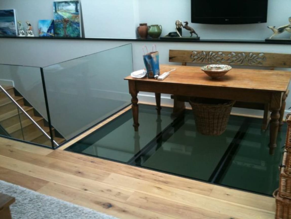 Glass floor room in London with table and chairs, compliant with regulations for safety and style